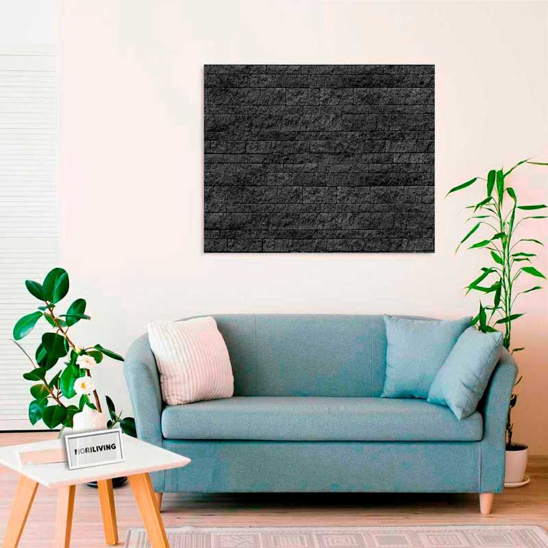 Wohnzimmer mit hellblauer Couch, weißem Beistelltisch und schwarzem Wandpaneel