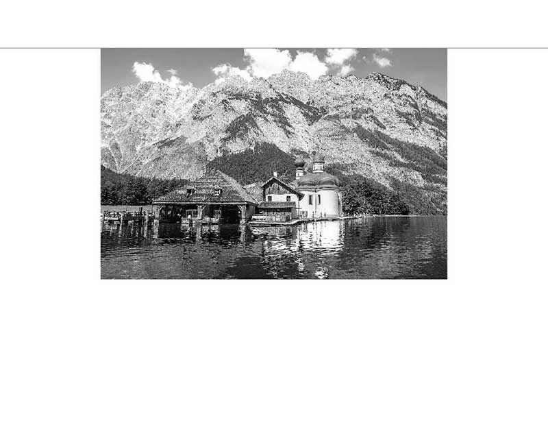 Idyllische Ansicht der Kirche St. Bartholomä mit den Berchtesgadener Alpen im Hintergrund am Königssee