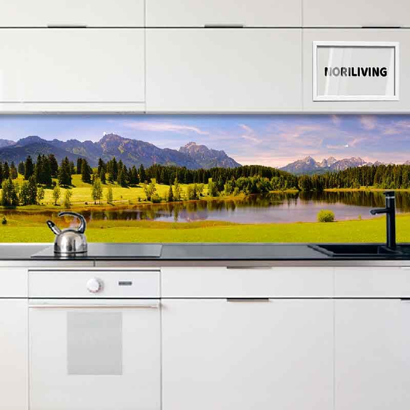 Moderne Küche mit dekorativer Rückwand, die eine malerische Berglandschaft mit See und Wäldern zeigt.