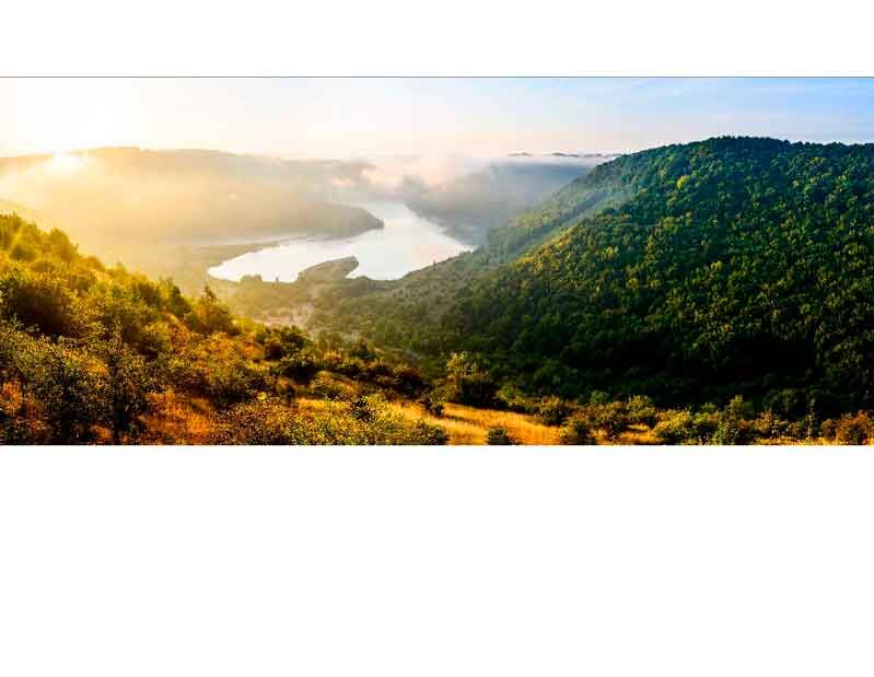 Malerische Landschaft mit Fluss, Hügeln und Sonnenstrahlen am Morgen