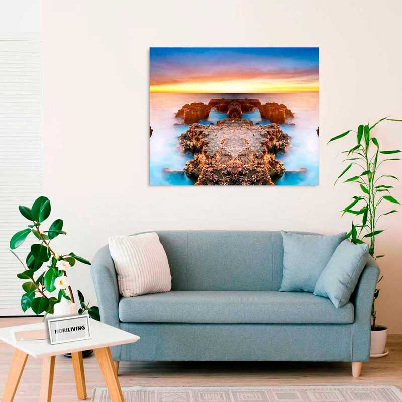 Elegantes Wohnzimmer mit blauem Sofa, Wandkunst mit Meereslandschaft und Zimmerpflanzen