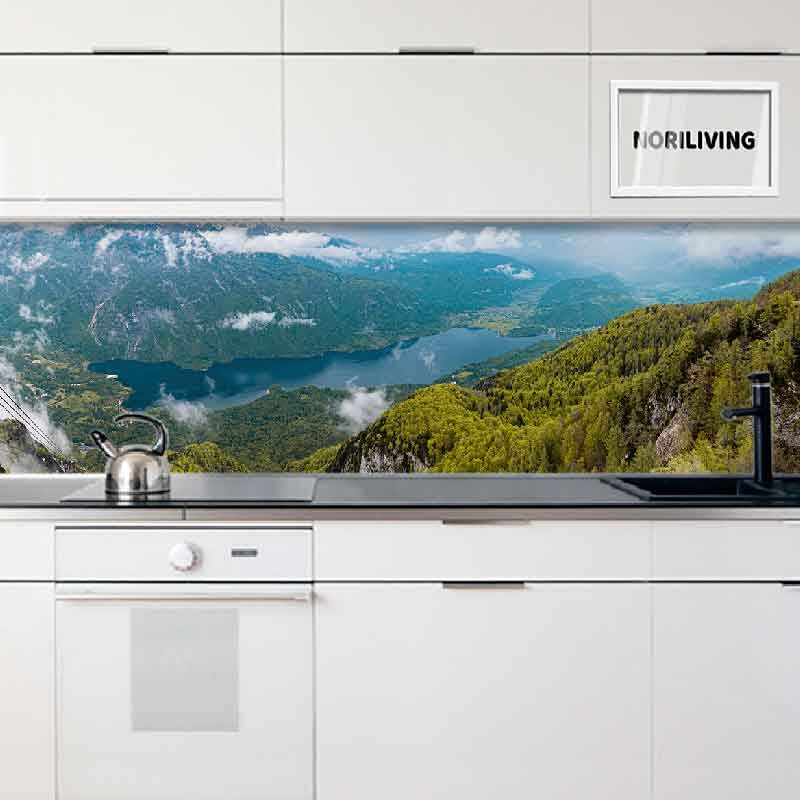 Küche mit weißem Design und Glasrückwand mit Landschaftsmotiv von Bergen und See