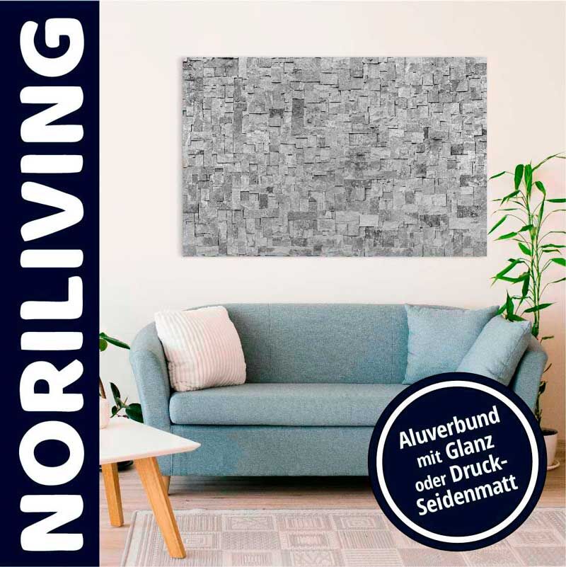 Ein stilvoll eingerichtetes Wohnzimmer mit einer blauen Couch, darauf liegenden Kissen und einem Kunstwerk an der Wand.