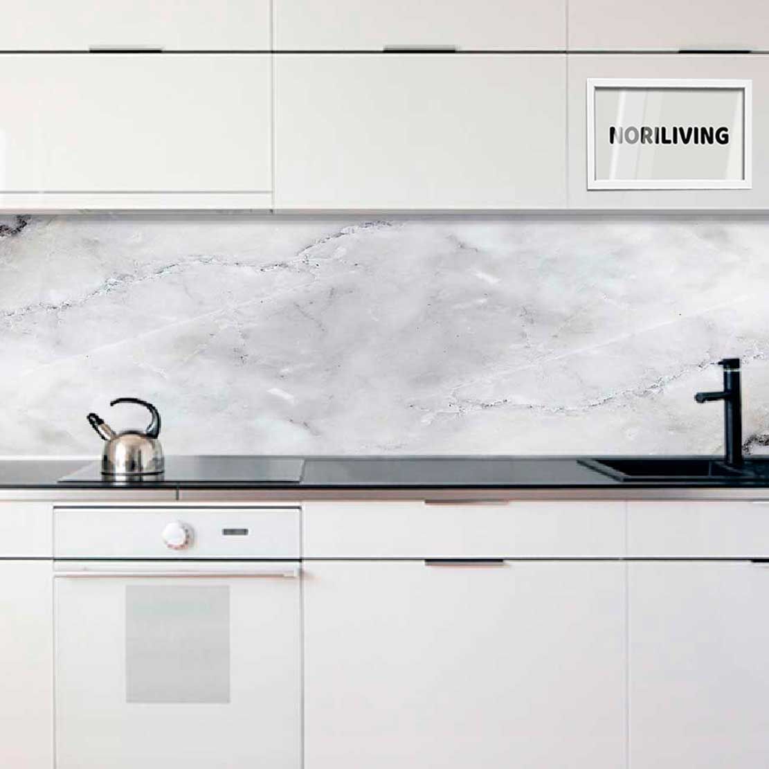 Helle, moderne Küche mit weißer Marmorrückwand, weißen Schränken, schwarzer Arbeitsplatte, Wasserkocher und Spüle