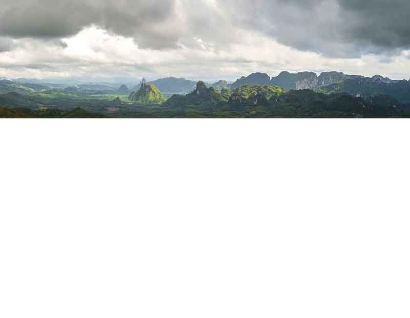 Panorama einer grünen Berglandschaft mit bewölktem Himmel im Hintergrund