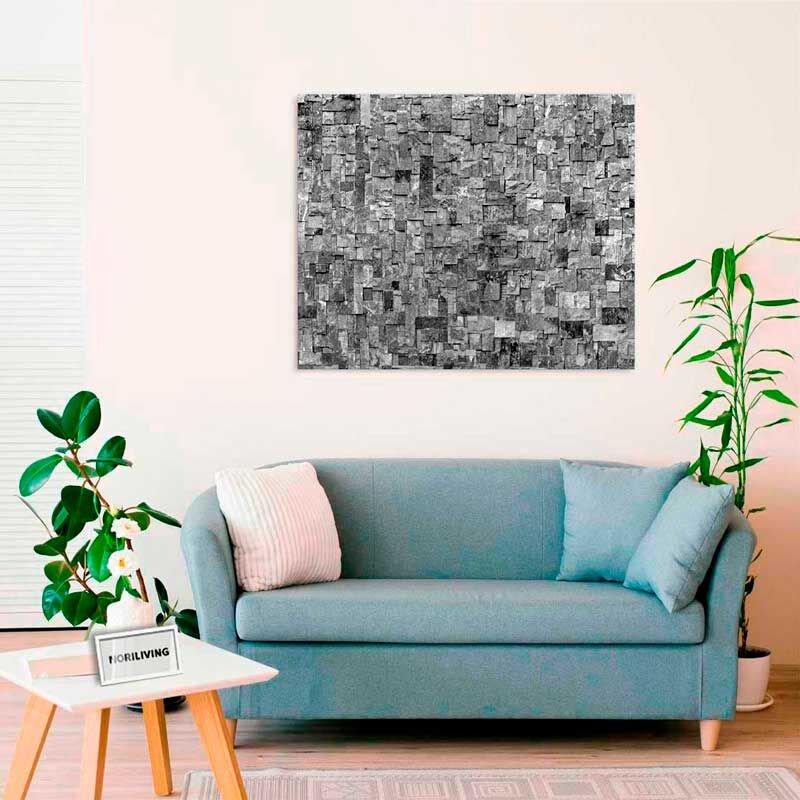 Gemütliches Wohnzimmer mit blauer Couch, Pflanzen und modernem grauen Kunstwerk an der Wand