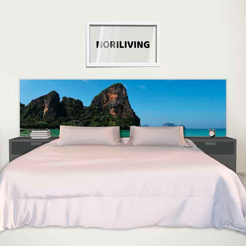 Minimalistisch eingerichtetes Schlafzimmer mit Bett und Landschaftsbild als Kopfteil, darunter ein Bild mit der Aufschrift Noriliving an der Wand.