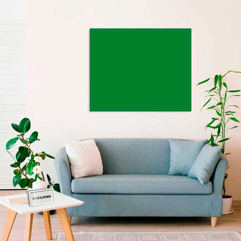 Wohnzimmer mit blauer Couch, grünem Kunstwerk an der Wand und Pflanzen im Raum