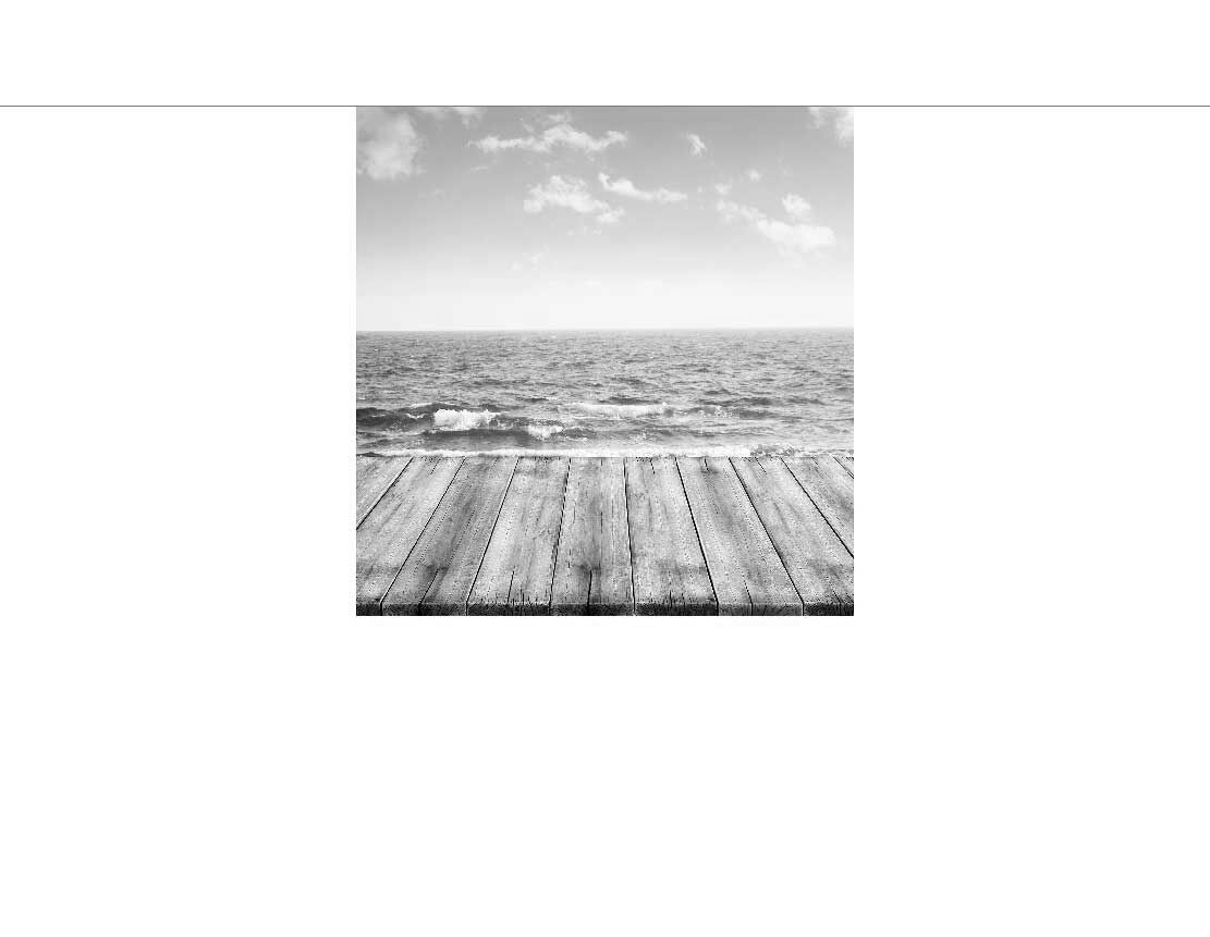 Ein Holzsteg, der zum Meer führt, mit einem bewölkten Himmel im Hintergrund.