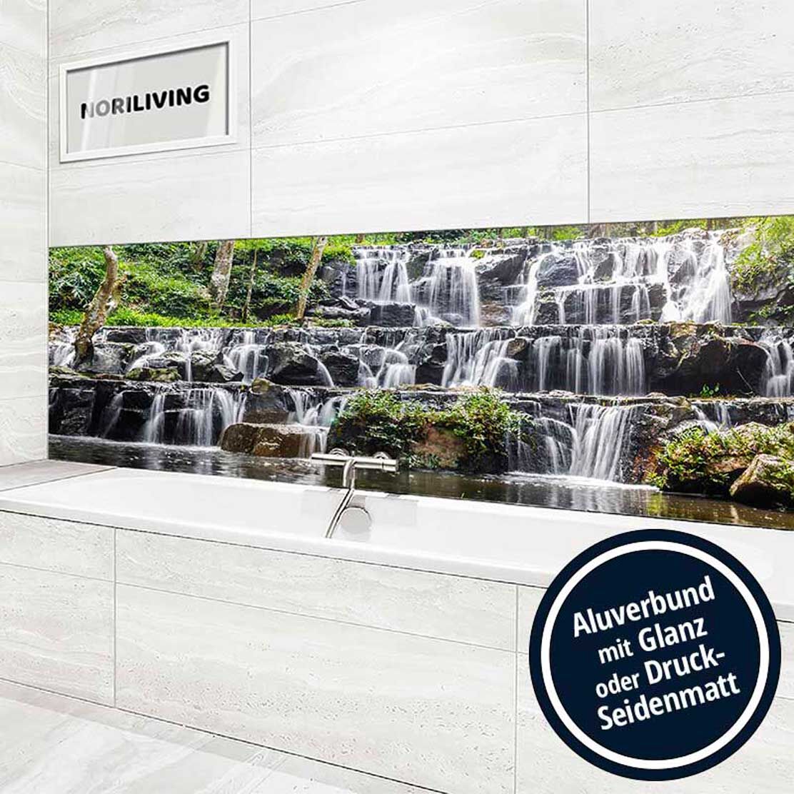 Modernes Badezimmer mit weißen Fliesen und einem Alubild-Panel, das einen malerischen Wasserfall zeigt, über der Badewanne.