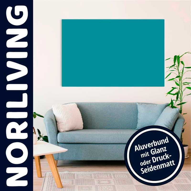 Ein stilvoll eingerichtetes Wohnzimmer mit einem blauen Sofa, Pflanzen und einem Alubild an der Wand.