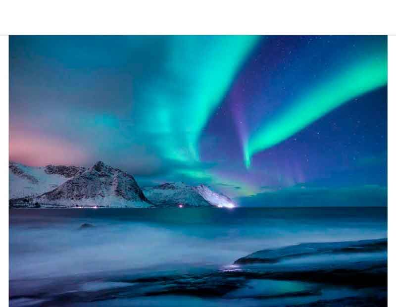 Faszinierendes Aurora Borealis über winterlicher Küstenlandschaft mit Bergen und Meer in Norwegen