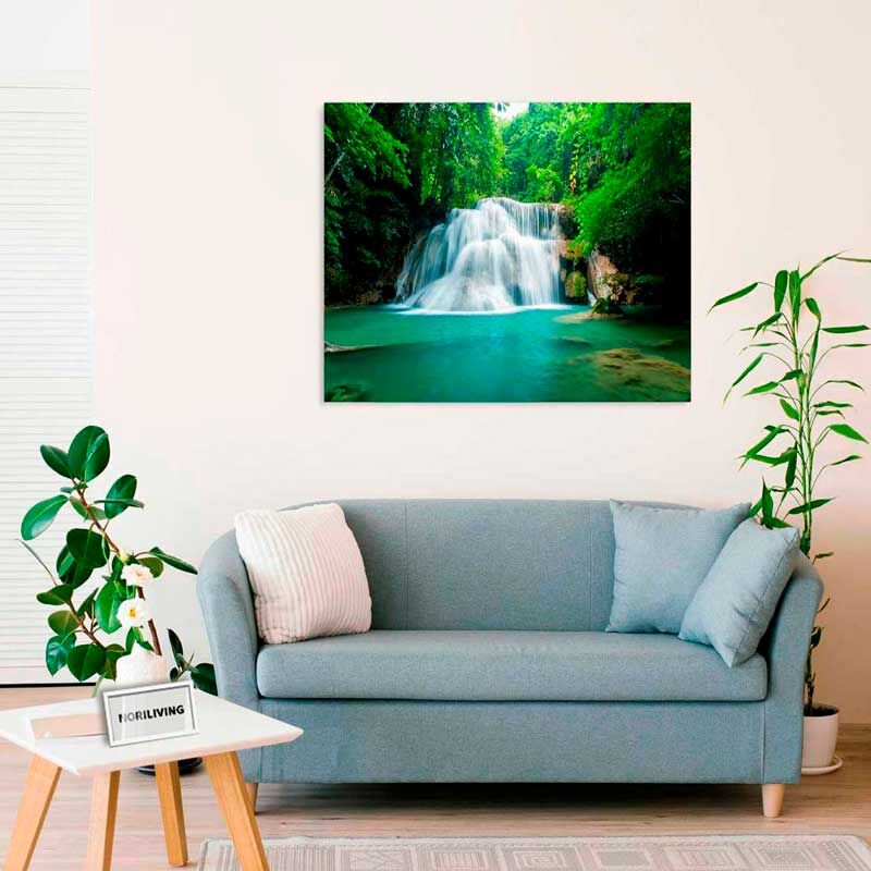 Modernes Wohnzimmer mit blauer Couch, dekorativen Kissen und einem Wandbild eines Wasserfalls, das eine entspannende Atmosphäre schafft.