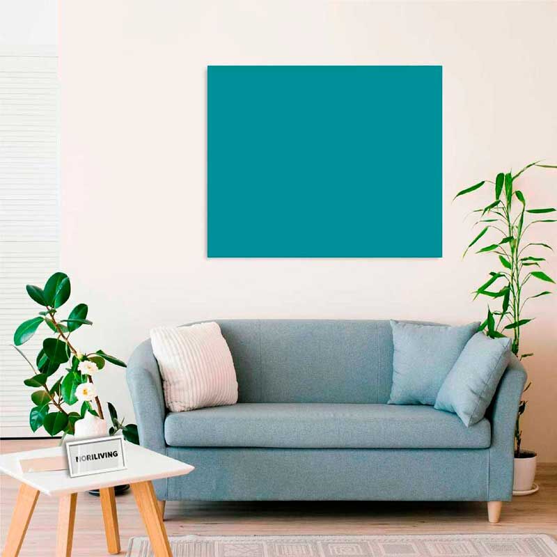 Ein stilvoll eingerichtetes Wohnzimmer mit einem hellblauen Sofa, einem Couchtisch und grünen Pflanzen im Hintergrund vor einer hellen Wand.