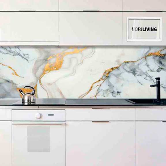 Weiße Küche mit einer eleganten Marmor-Rückwand in grau-goldenem Muster und Edelstahl-Wasserkocher auf der Arbeitsplatte