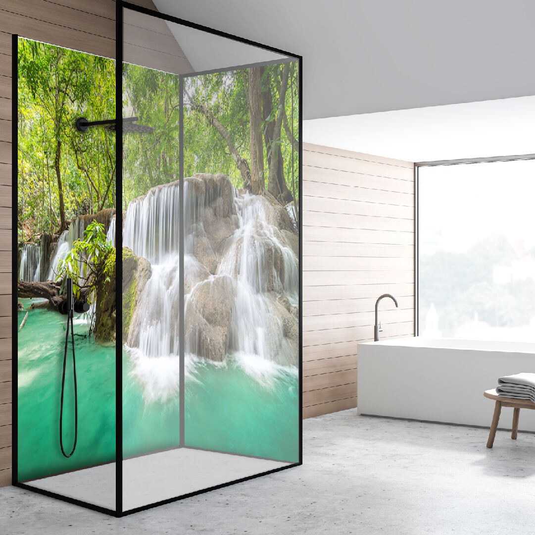 Moderne Duschkabine mit Natur-Wasserfall-Design Eine stilvolle Duschkabine mit einem Design, das einen natürlichen Wasserfall inmitten eines Waldes zeigt, daneben eine freistehende Badewanne vor einem großen Fenster.
