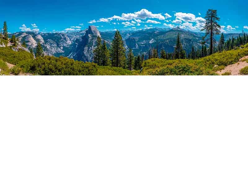 Blick auf die Landschaft des Yosemite-Nationalparks mit Bergen, Bäumen und blauem Himmel
