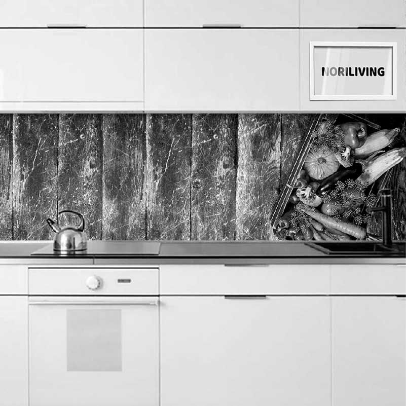 Schwarz-weiß-Bild einer modernen Küche mit einer Holzmuster-Rückwand und einem Korb voller Gemüse auf der Arbeitsplatte
