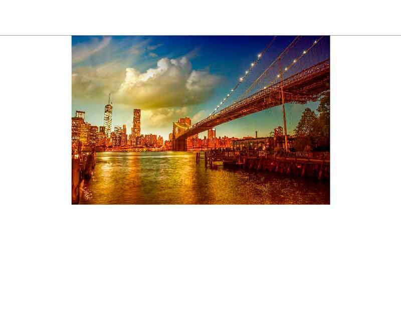 Ein majestätischer Blick auf die Brooklyn Bridge im Abendlicht, mit den Lichtern der New Yorker Skyline im Hintergrund.