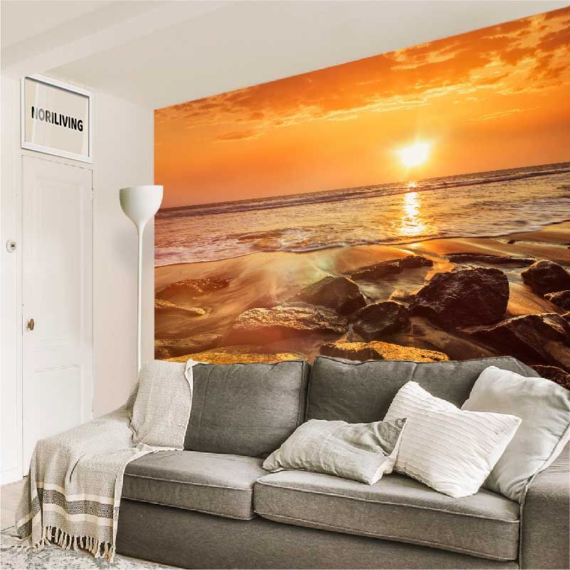 im Wohnzimmer eingebaute Wohnzimmerrückwand mit Motiv Wellen und Felsen am Strand bei Sonnenuntergang 844