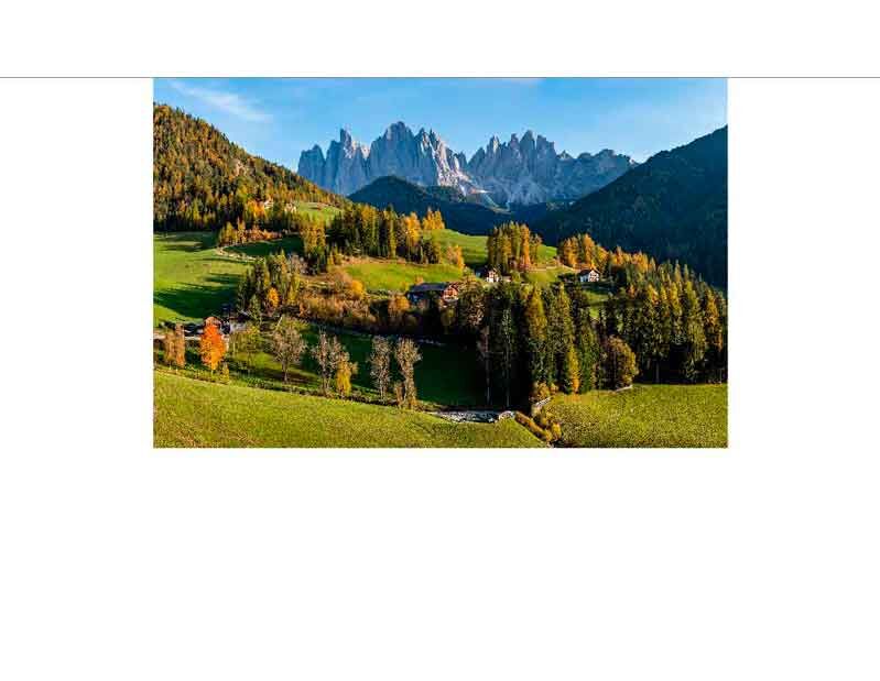 Herbstliches Panorama der Dolomiten mit bunten Wäldern und grünen Wiesen