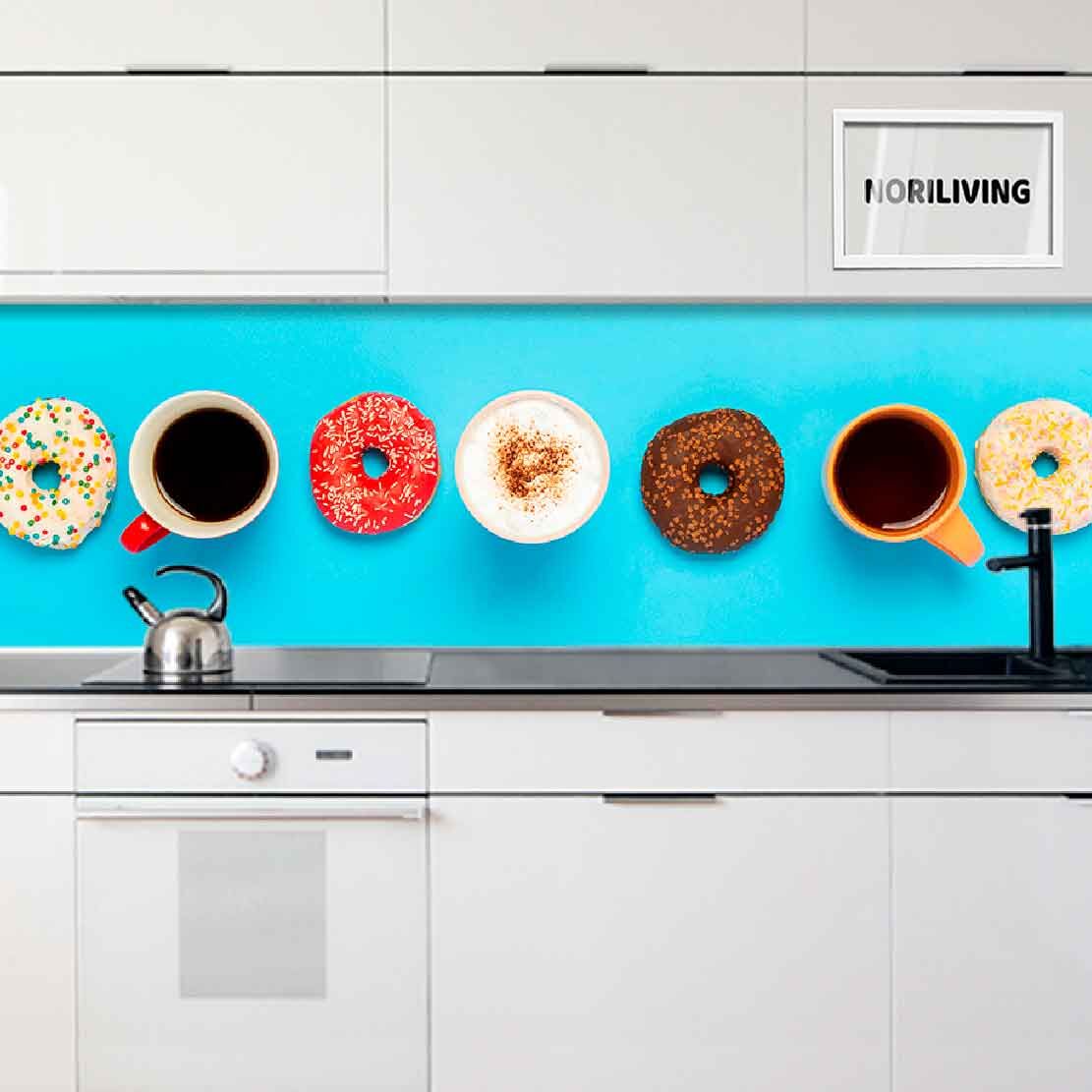 Weiße Küchenschränke mit blauer Glasrückwand, dekoriert mit Donuts und Kaffeetassen