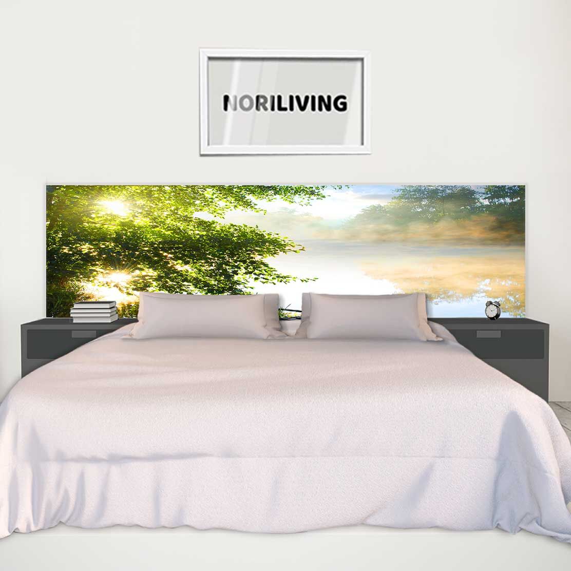 Ein stilvoll eingerichtetes Schlafzimmer mit einem großen Bett, flankiert von Nachttischen. Das Kopfteil zeigt ein beruhigendes Naturbild mit Bäumen und einem See.