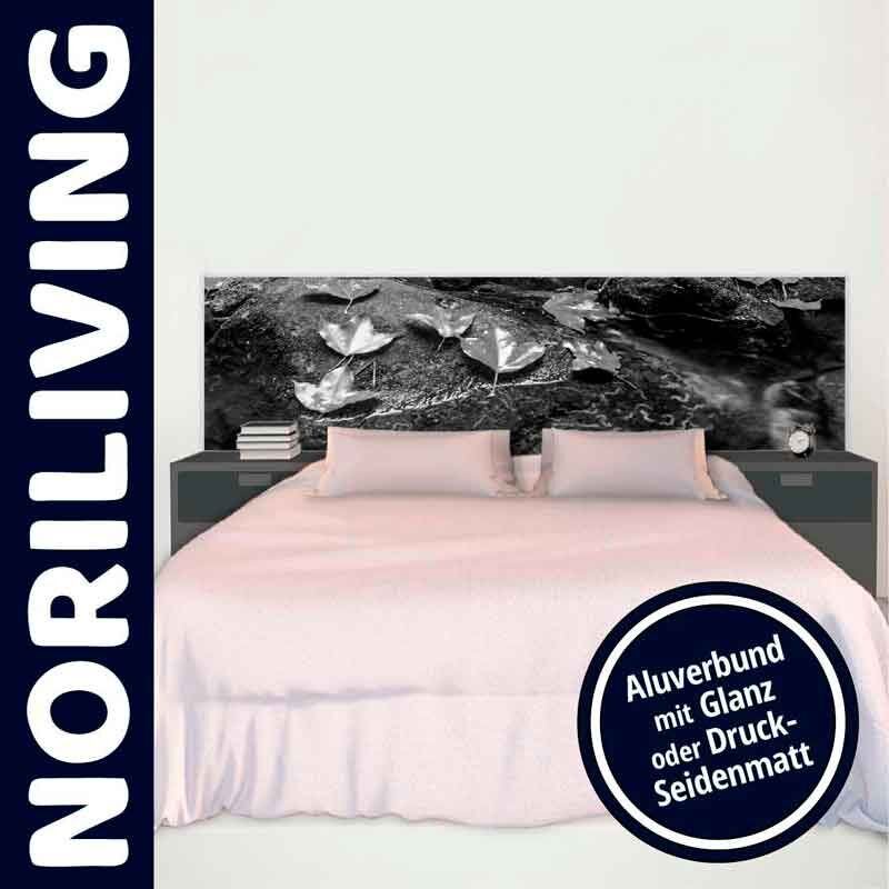 Schlafzimmer mit einem Bett, dessen Kopfteil aus glänzendem Alu-Verbund mit einem floralen Muster besteht, umgeben von zwei Nachttischen.