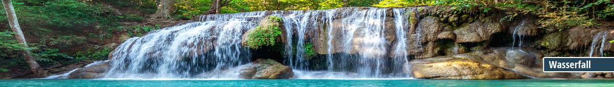 Naturbelassener Wasserfall in tropischem Wald Ein breiter Wasserfall fließt über eine Felsformation, umgeben von üppigem grünen Wald.