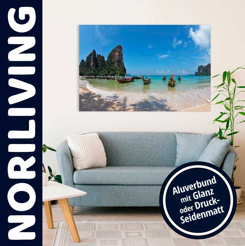 Modernes Wohnzimmer mit blauer Couch und tropischem Strandbild im Alu-Druck