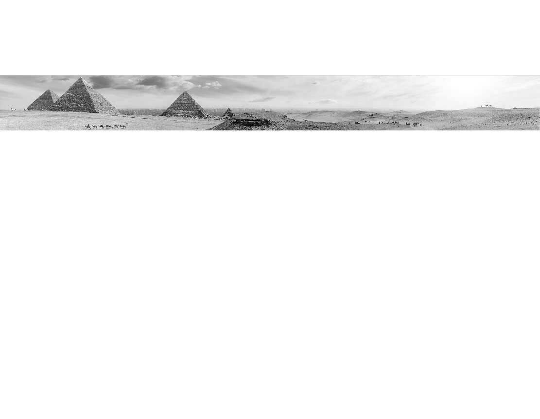 Schwarz-Weiß-Panorama der Pyramiden von Gizeh in Ägypten mit einer Kamelkarawane im Vordergrund