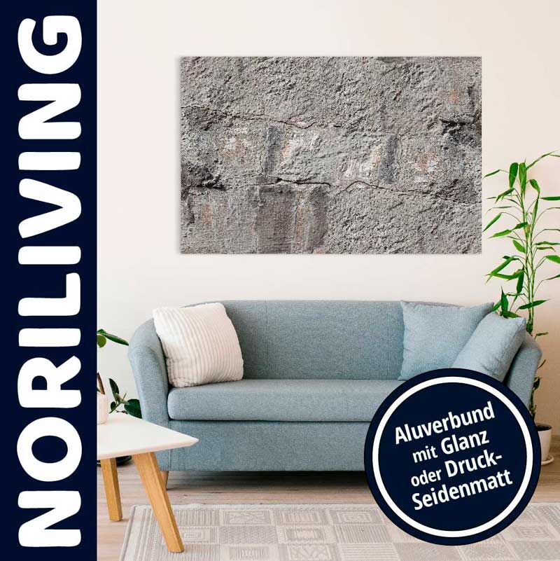 Schick eingerichtetes Wohnzimmer mit blauem Sofa, Pflanzen und einem Aluverbundbild mit rauer, texturierter Oberfläche an der Wand. Das Bild ist in Glanz oder Druck-Seidenmatt verfügbar.