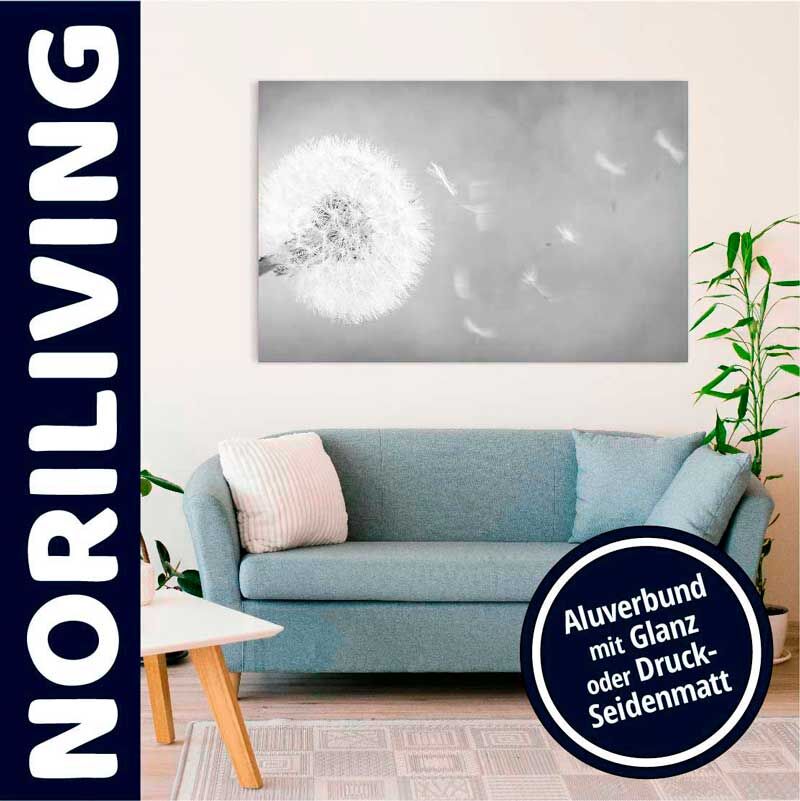 Stilvolle Wohnzimmerdekoration mit blauem Sofa und Löwenzahn-Wandbild in Alu-Druck.