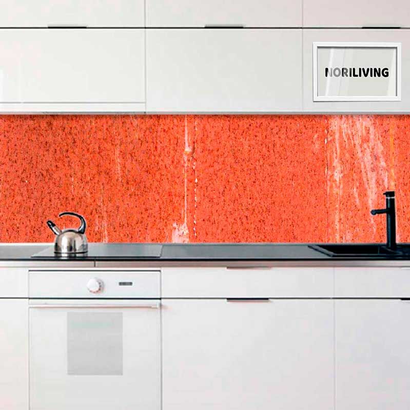 Weiße Einbauküche mit roter Steinrückwand, schwarzem Wasserhahn und Metallkessel auf dem Herd