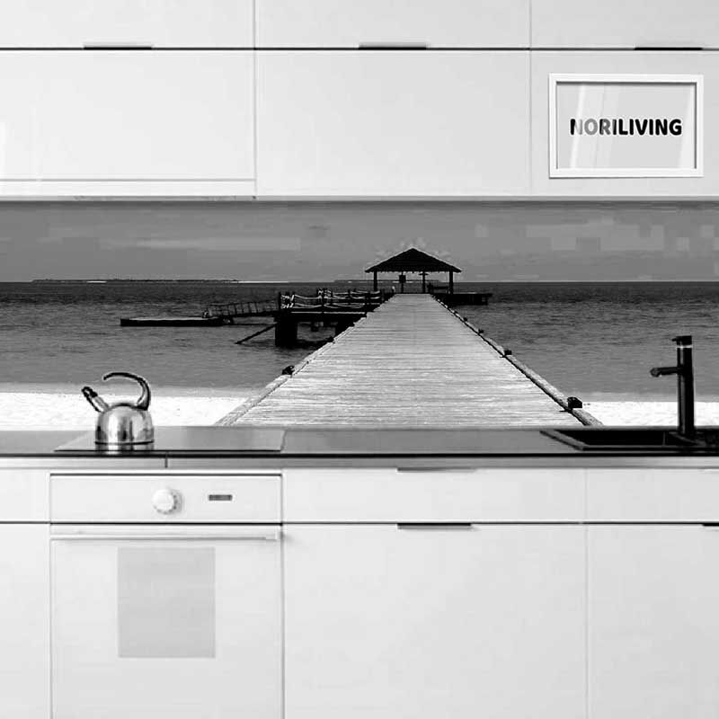 Küche mit weißer Einrichtung und Fototapete eines Holzstegs, der ins Meer führt