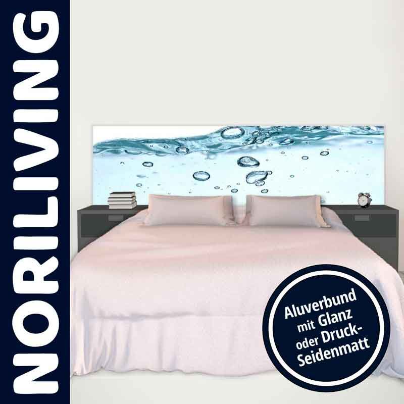 Schlafzimmer mit Bett, das ein Kopfteil aus Aluverbund mit Wasserblasen-Motiv zeigt, flankiert von zwei Nachttischen