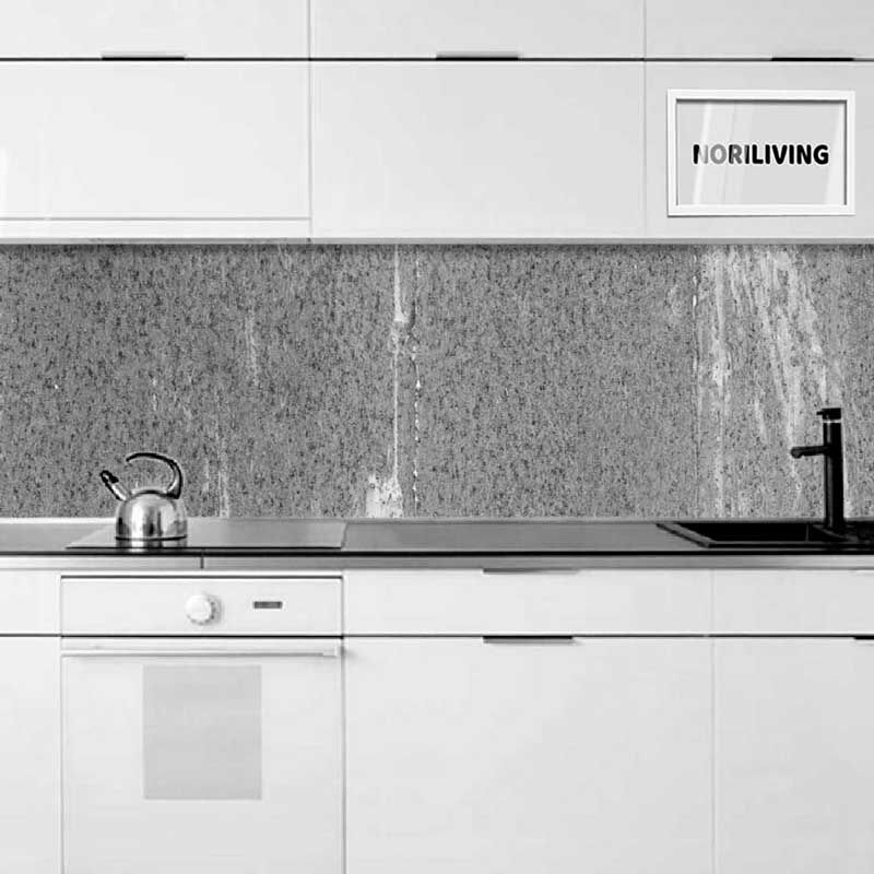 Helle weiße Küchenzeile mit Granit-Rückwand, Wasserkocher auf dem Herd und NoriLiving-Rahmen an der Wand