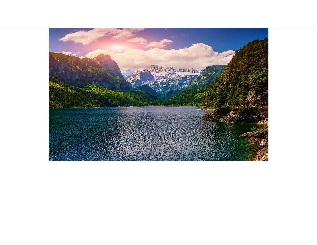 Idyllische Berglandschaft mit See, umgeben von grünen Wäldern und schneebedeckten Gipfeln.
