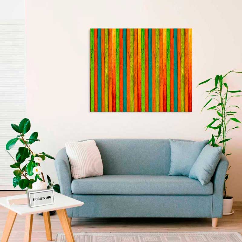 Ein Wohnzimmer mit einem blauen Sofa, dekoriert mit einem farbenfrohen Holzmuster an der Wand, Pflanzen und einem Couchtisch.