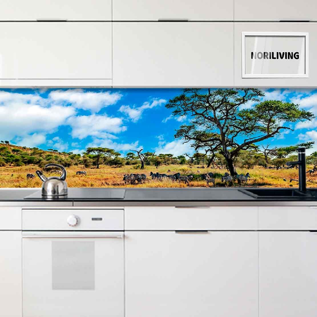 Moderne Küche mit dekorativer Rückwand, die eine afrikanische Savannenlandschaft mit Akazienbäumen und blauem Himmel zeigt.