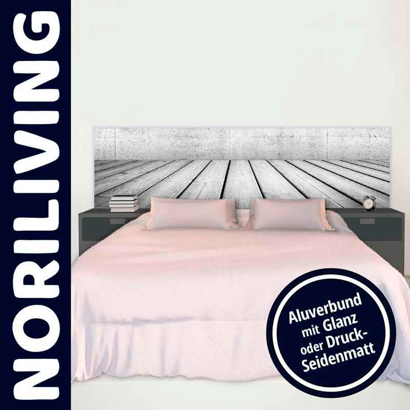 Schlafzimmer mit einem Bett, das ein Kopfteil mit Holzmuster hat, flankiert von zwei Nachttischen, die Bücher und eine Uhr tragen. Noriliving-Logo und Hinweis auf Alubund mit Glanz oder Druck-Seidenmatt sind sichtbar.