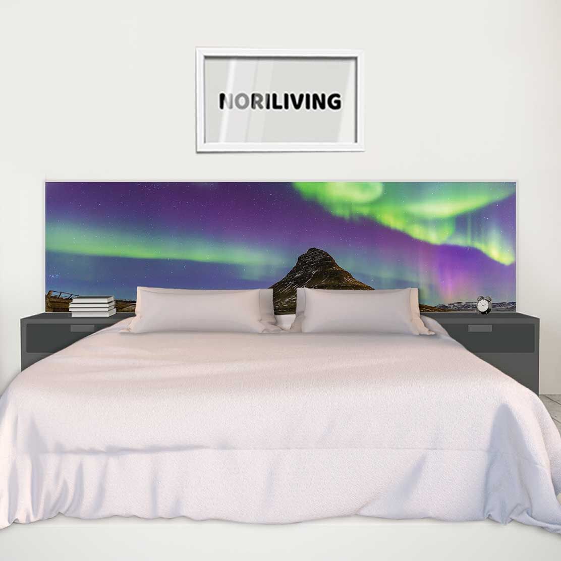 Modernes Schlafzimmer mit einem großen Bett und einem Kopfteil mit Nordlicht-Motiv, umgeben von zwei Nachttischen und einem gerahmten Bild mit dem Schriftzug 'Noriliving' an der Wand.