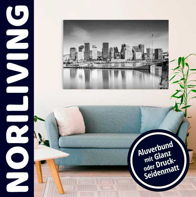 Helles Wohnzimmer mit blauem Sofa, Kissen und großem Alubund-Wandbild von NORILIVING in schwarz-weiß über der Couch.