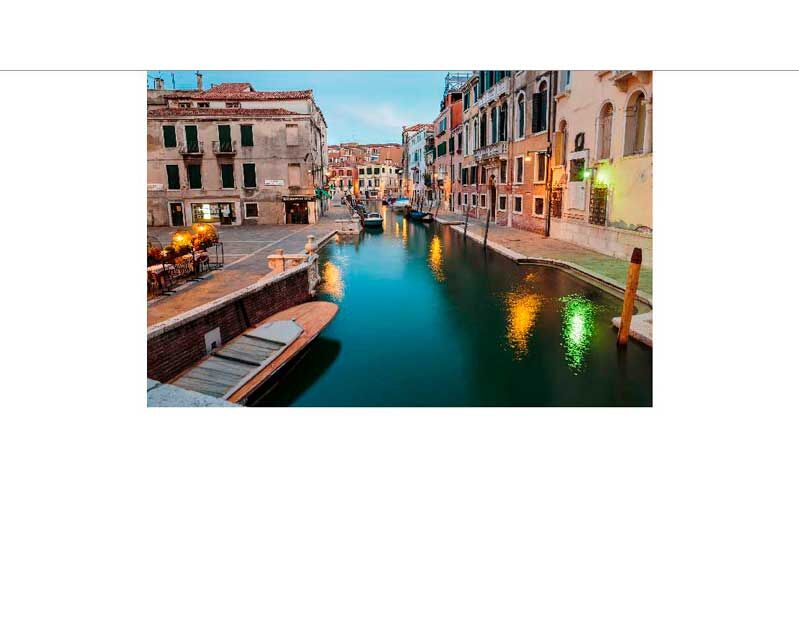 Ein malerischer Kanal in Venedig im Abendlicht, gesäumt von historischen Gebäuden und Restaurants
