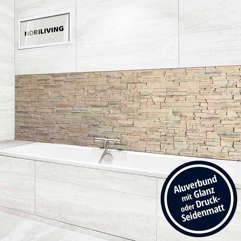 Badezimmer mit moderner Steinwand, Badewanne und Aufschrift 'Aluverbund mit Glanz oder Druck-Seidenmatt'. Ausstellungsraum von Noriliving.