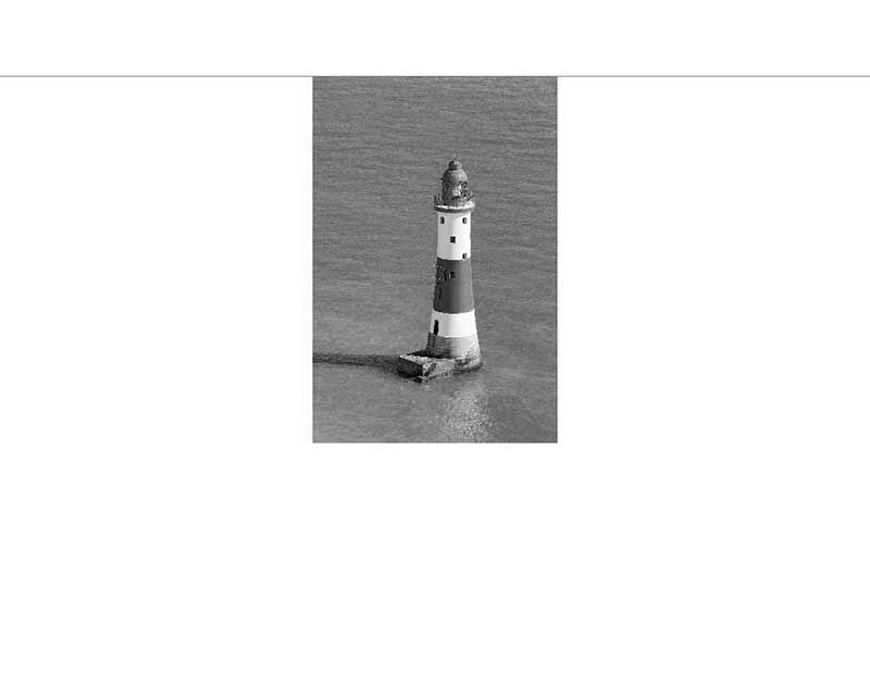 Ein einzelner Leuchtturm steht im Meer, aufgenommen in Schwarz-Weiß.