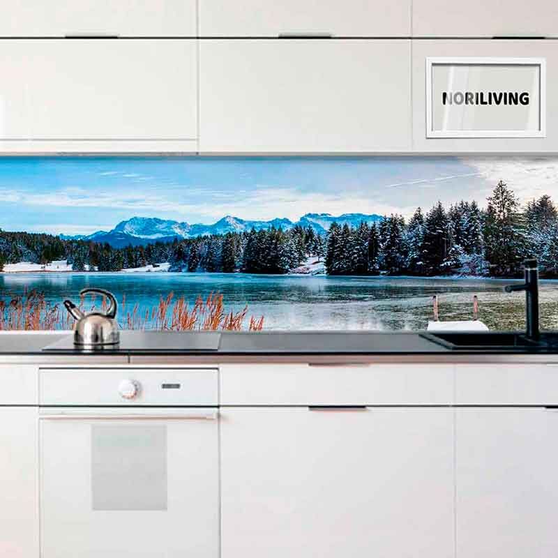 Moderne weiße Küche mit einer Rückwand, die eine winterliche Landschaft mit einem See und schneebedeckten Bergen zeigt.
