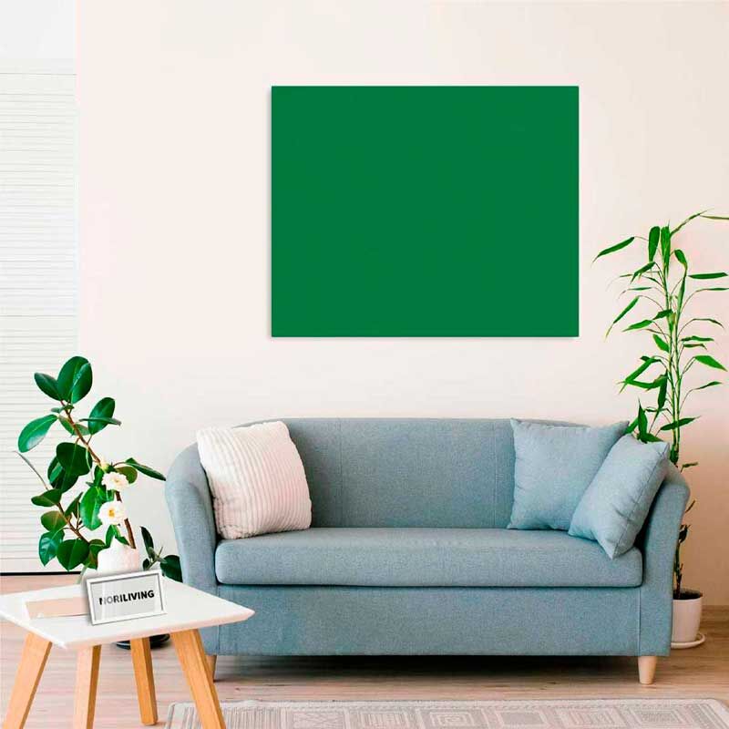 Wohnzimmer mit hellblauem Sofa, grüner Leinwand an der Wand, Pflanzen und kleinem weißen Tisch
