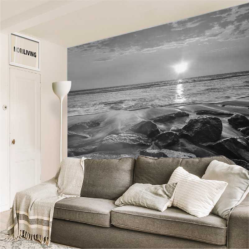 im Wohnzimmer eingebaute Wohnzimmerrückwand mit Motiv Wellen und Felsen am Strand bei Sonnenuntergang 844 schwarz-weiß