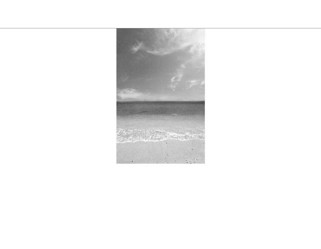 Schwarz-Weiß-Foto eines Strandes mit sanften Wellen und bewölktem Himmel